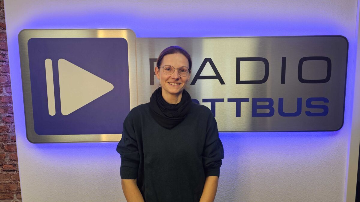 Katja Koßack vor dem Radio Cottbus Logo