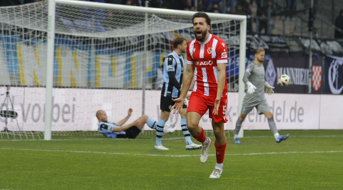 Dominik Pelivan jubelt auf dem Rasen im Stadion des FC Energie Cottbus