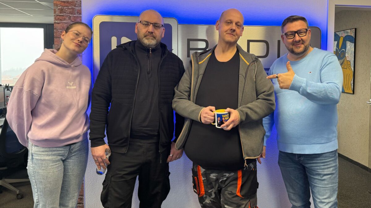 Die Wacher Macher Luka Stadelmeier und Ronny Gersch vor dem Radio Cottbus Logo mit New Mc Pütt'n Inhabern Sebastian und Georg