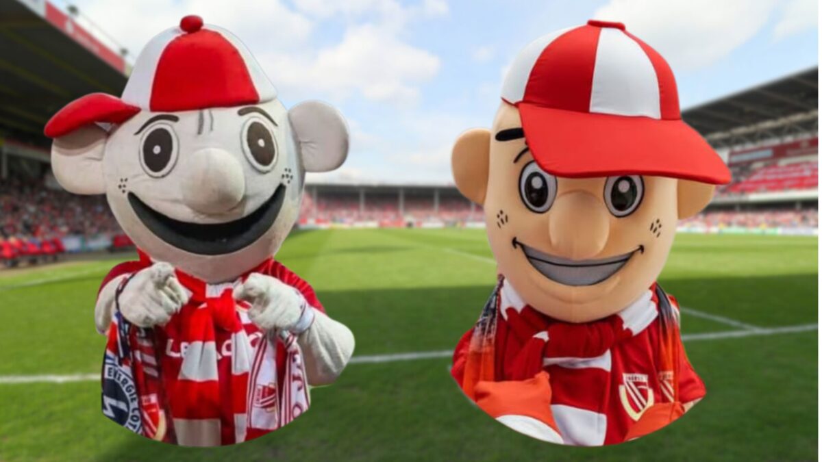 Im Hintergrund ist verschwommen das LEAG Energie Stadion in Cottbus zu sehen, davor ist links das alte Lauzi-Maskottchen und rechts das neue Lauzi-Maskottchen vom FC Energie Cottbus zu sehen